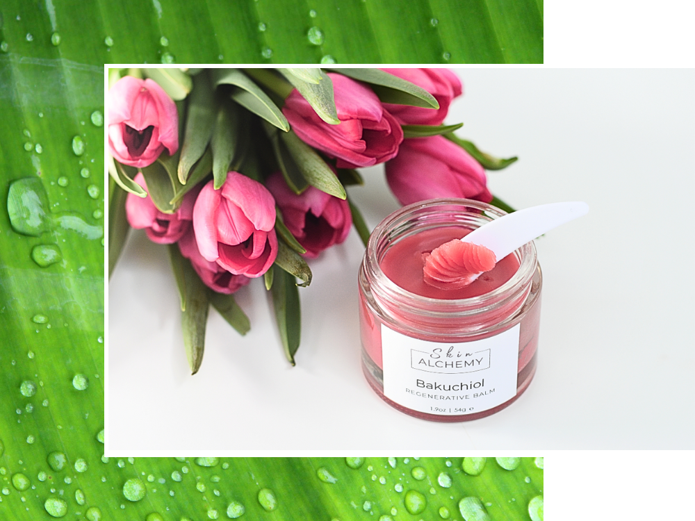 Jar of skincare product with a spoon, surrounded by pink tulips and green leaves.
