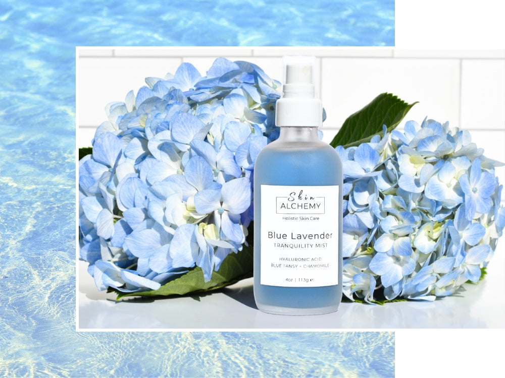 Bottle of Blue Lavender Tranquility Mist with hydrangeas on a light blue background
