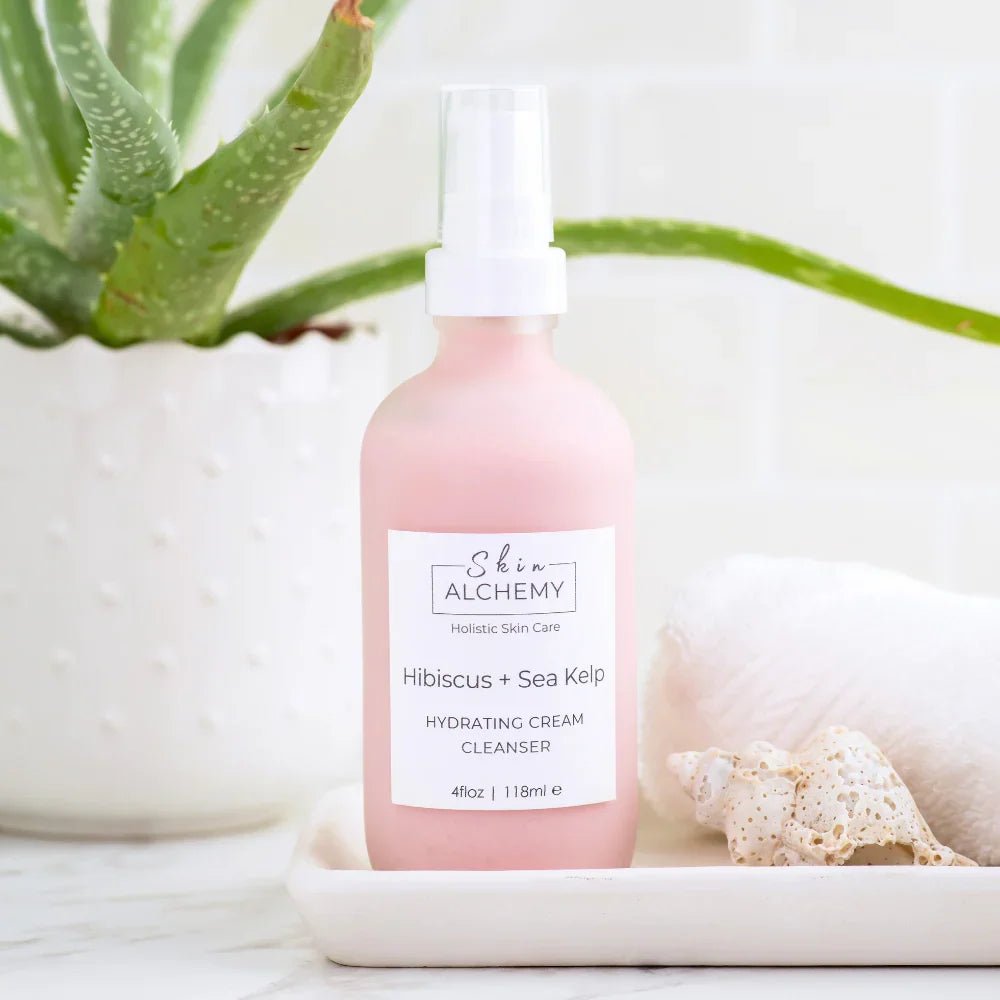 Pink cream cleanser with an aloe plant on a white background