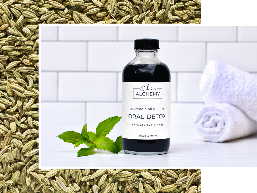 Bottle of 'Shin Alchemy' oral detox with fennel seeds and mint leaves on a white tiled background