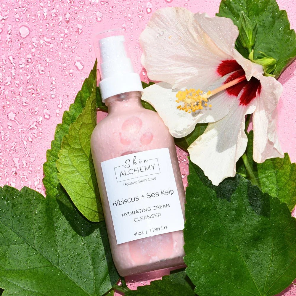 Pink cream cleanser with a hibiscus flower on a pink background