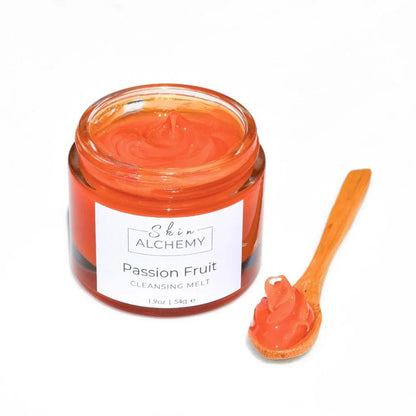 orange face cleanser in a jar on a white background