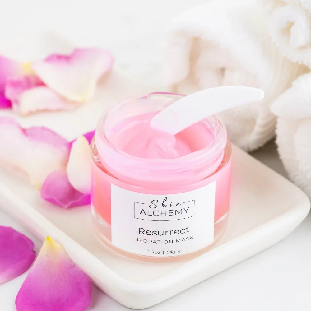 Pink face mask in a jar with a white background and rose petals