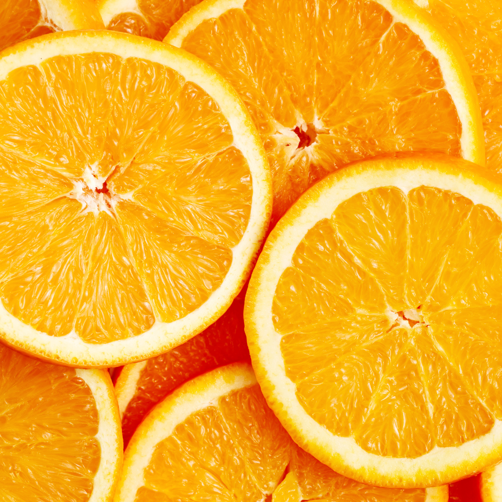 Close-up of sliced oranges with a bright orange background